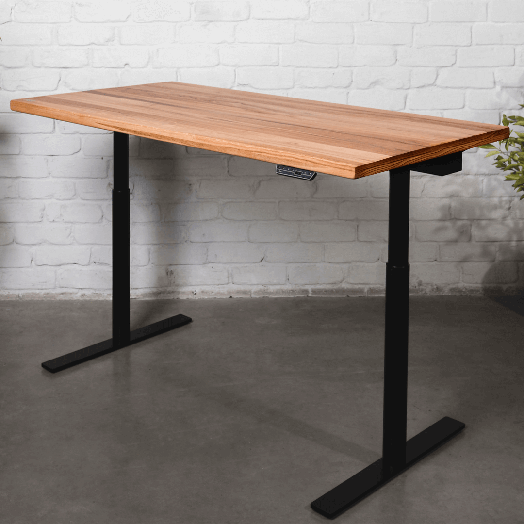 solid-oak-standing-desk-golden-crust-black with golden crust finish and black frame against white brick wall