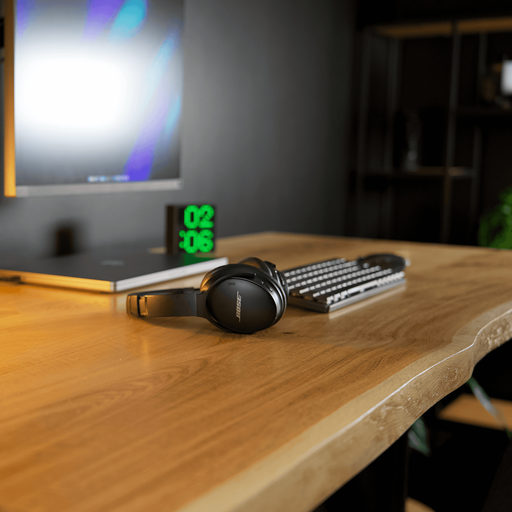 Close-up of the Alive Oak desk surface with accessories, showcasing the live edge design.