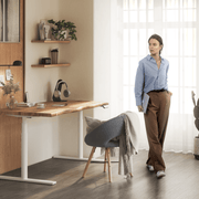 Height-adjustable oak desk by OAKO Denmark in a stylish home office setting. Features a natural wood live edge design with a white frame, complemented by modern decor, a cozy chair, and natural light. Ideal for productive and ergonomic workspaces.